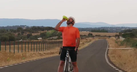 Road cyclist man drinking water resting during a training Stock Footage 218978205