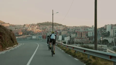 Road cyclists riding on sunset mountain road Stock Footage 107874934