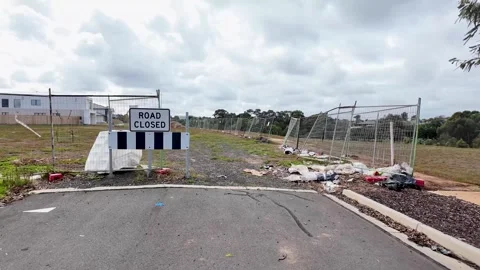 Road dead end with a "Road Closed" barrier sign, and undeveloped land Stock Footage 308047994