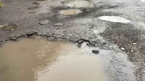 Road destroyed after winter. Puddles in the pits in the road Video stock 160032161