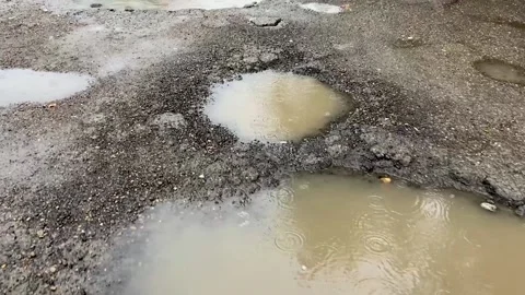 Road destroyed after winter. Puddles in the pits in the road Stock Footage 162018358