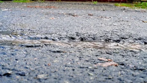 Road destroyed after winter. Water flow on the road Stock Footage 250321814