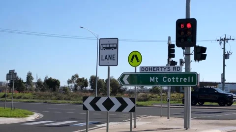 A road direction sign for Mt Cottrell at the traffic lights of an intersection. Vídeo Stock 275501911