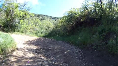 Off-road driving around a bend towards mountains via a rocky cobblestone road. Stock-Footage 52706401