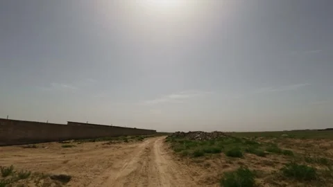 Off-road driving on dirt path through open landscape with clear blue sky Stock Footage 341974248