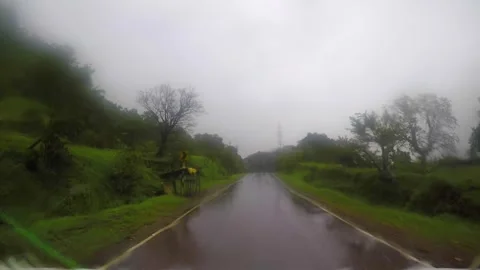 By road driving through dense forest in rainy season in india Stock Footage 310777830