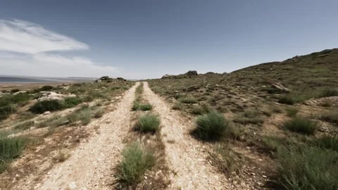 Off-road driving on winding dirt path through rocky terrain and grassland Stock Footage 341974923