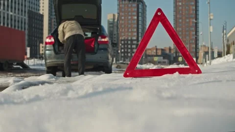 Road emergency in winter man looks for tools in the trunk of a broken car. Stock Footage 331097286