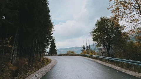 Road in the fall forest against the background of mountains Stock Footage 254606423