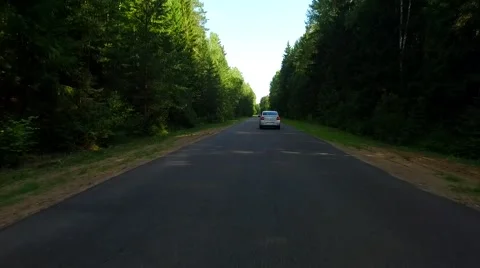 Road in the forest and a white car Stock Footage