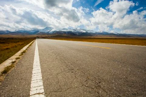 Road going through field into the mountains in Qinghai province, China Stock-Fotos