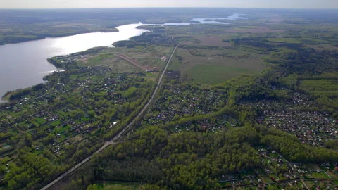 The road going through a large suburb village in the forest on the banks of a Stock Footage 229477080