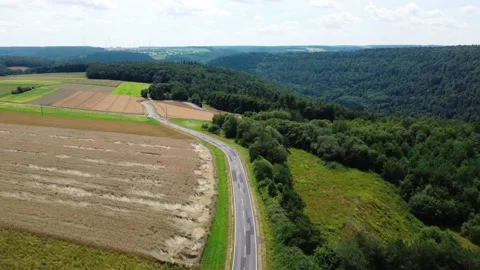The road on a high hill through the meadows of the field and the forest Stock Footage 161065729