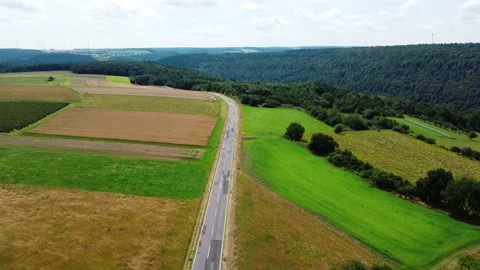 The road on a high hill through the meadows of the field and the forest Stock Footage 161065835