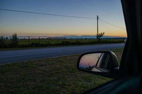 Road from the inside of a car and the reflection of the rear-view mirror of t Stock Photos