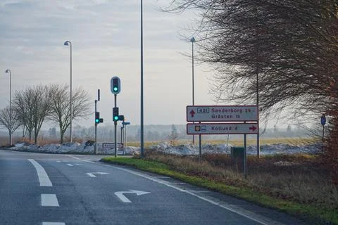 Road intersection with traffic lights and border direction signs Stock Photos
