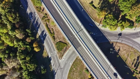 Road intersection with vehicles and greenery in a city landscape during daytime Video stock 347631734