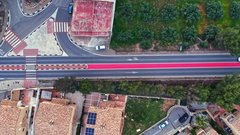 Road intersection viewed from above with buildings, trees, and cars nearby Stock Footage 340856825