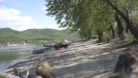 Off-road jeep pulling  boat and trailer out of the water at a Danube. Stock Footage 152016435