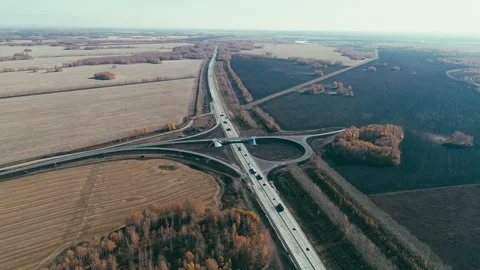Road junction under construction. Trucks and cars drive along the highway in the Stock Footage 136247179