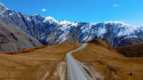 Road leading to famous Gergeti Trinity Tsminda Sameba Church in Mount Kazbegi Stock Footage 224907101