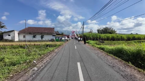 Road leads through a bright, rural landscape Stock Footage 345197329