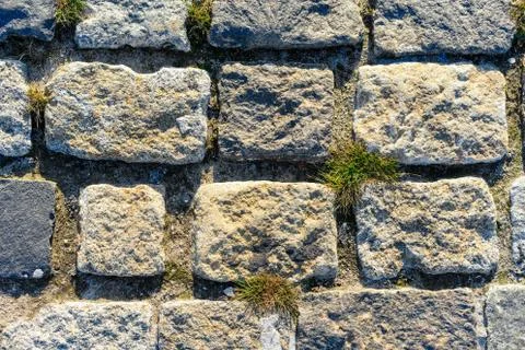 Road lined with rough rough gray stone as background or texture. Stock Photos