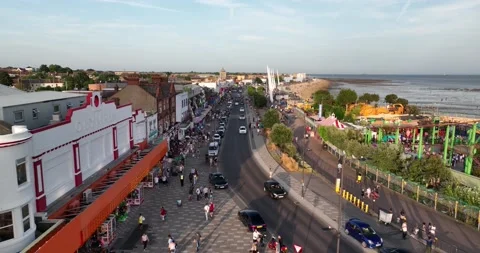 Road lined by shops and restaurants on one side and sand beach on other Stock-Footage 202176428