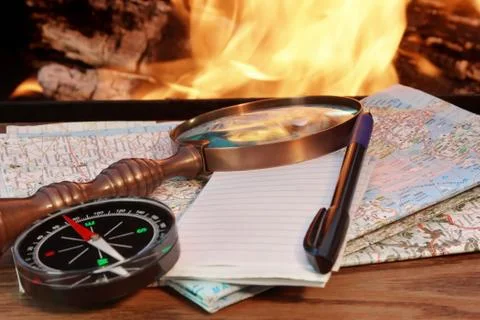 Road maps, compass,  notebook, pen and a magnifying glass Stock Photos