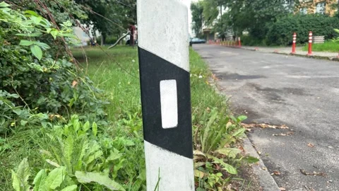 Road marker post with black and white reflective panel on roadside 스톡 동영상 344041491