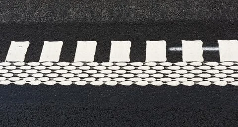 Road markings on asphalt surface featuring white pedestrian crosswalk lines.. Stock Photos