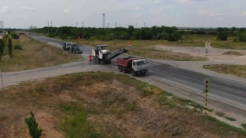 A road milling machine cuts old asphalt and loads it into a dump truck. Stock Footage 145466064