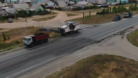 A road milling machine cuts old asphalt and loads it into a dump truck. Stock Footage 145466078