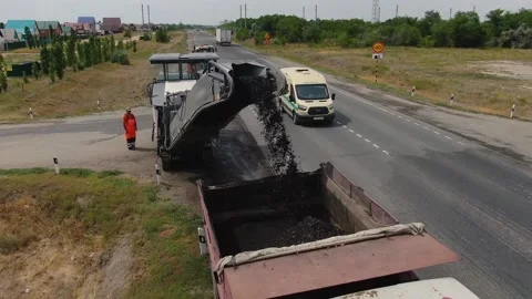 A road milling machine cuts old asphalt and loads it into a dump truck. Stock Footage 145466081