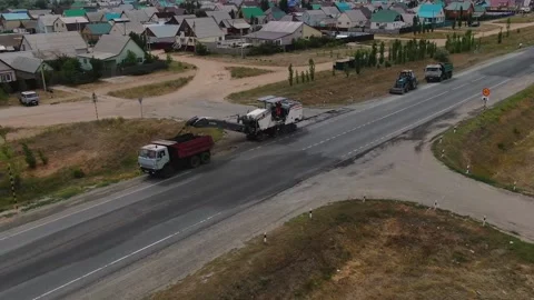 A road milling machine cuts old asphalt and loads it into a dump truck. Stock Footage 145466083