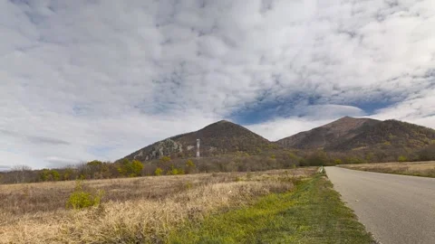 The road to Mount Beshtau and clouds floating behind the mountain Stock Footage 289728325