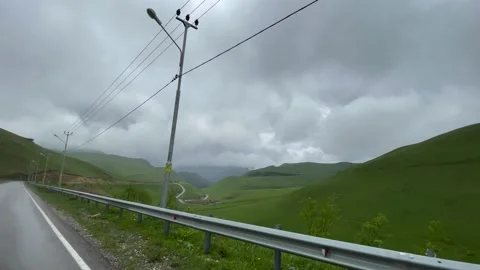 Road in Mountains. Low Clouds. Green Grass. View from the Car 05 Stock Footage 155619753