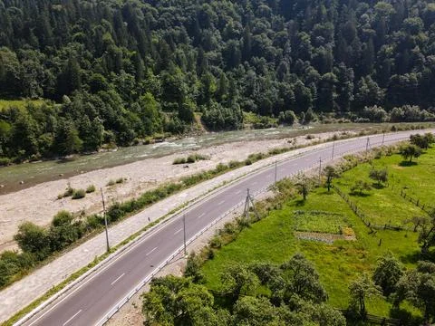 A road in the mountains, with a river flowing between the bridges Stock Photos