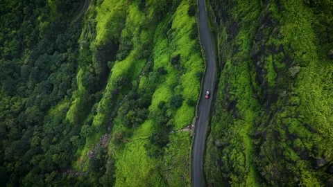 Road in the mountains. A Single Car driving on road in green mountains beautiful Stock Footage 285930865