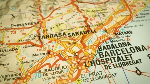 Road network leading to barcelona, spain – gliding over atlas map Stock Footage 345385060