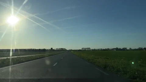 Road in open landscape with clear sky and sun, serene and calm scene with Stock-Footage 342752448