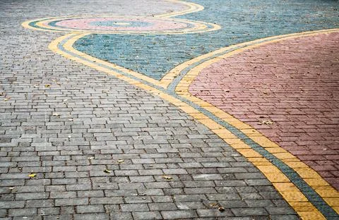 The road paved with colored stone blocks with decorations . Stock Photos