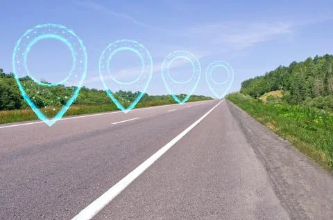 Road with polygonal pointers. Highway along green forests and blue sky. Sum.. Stock Photos