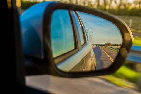 The road is reflected in the side mirror of the car Stock Photos
