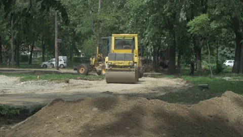 Road roller and grader distribute and flatten road before asphalting. Vídeo Stock 76989060