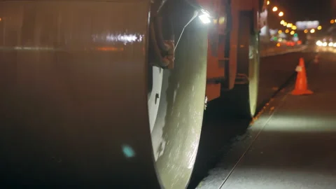Road roller close-up, drum of road roller laying asphalt. Road repair at night Stock Footage 154988735