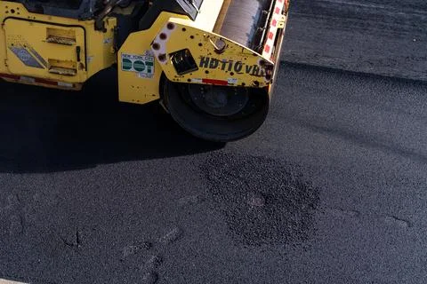 Road roller compacting fresh asphalt in Brooklyn Photos