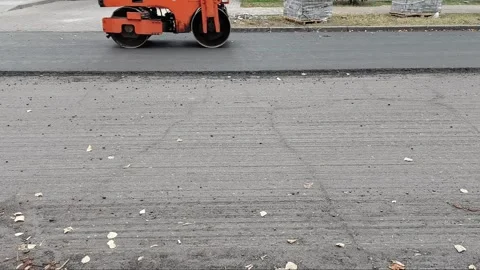Road roller compacts the new asphalt layer. Roadworks. Road repair work on a Stock-Footage 255635173