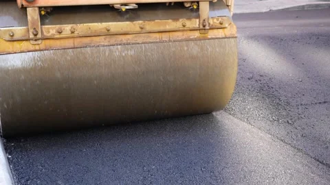 Road roller pressing fresh warm mix asphalt close-up Stock Footage 253231034