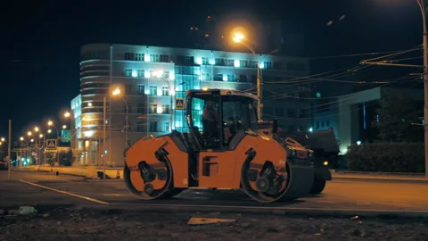 The road roller stands against the background of night city lights. Road surface Stock-Footage 152639107